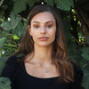 Woman outdoors wearing the silver Sacred Fusion Star of David necklace. This unique Judaica gift contains the entire Tanakh on a 0.2" nanochip. Ideal for Bat Mitzvahs, weddings, or spiritual milestones.